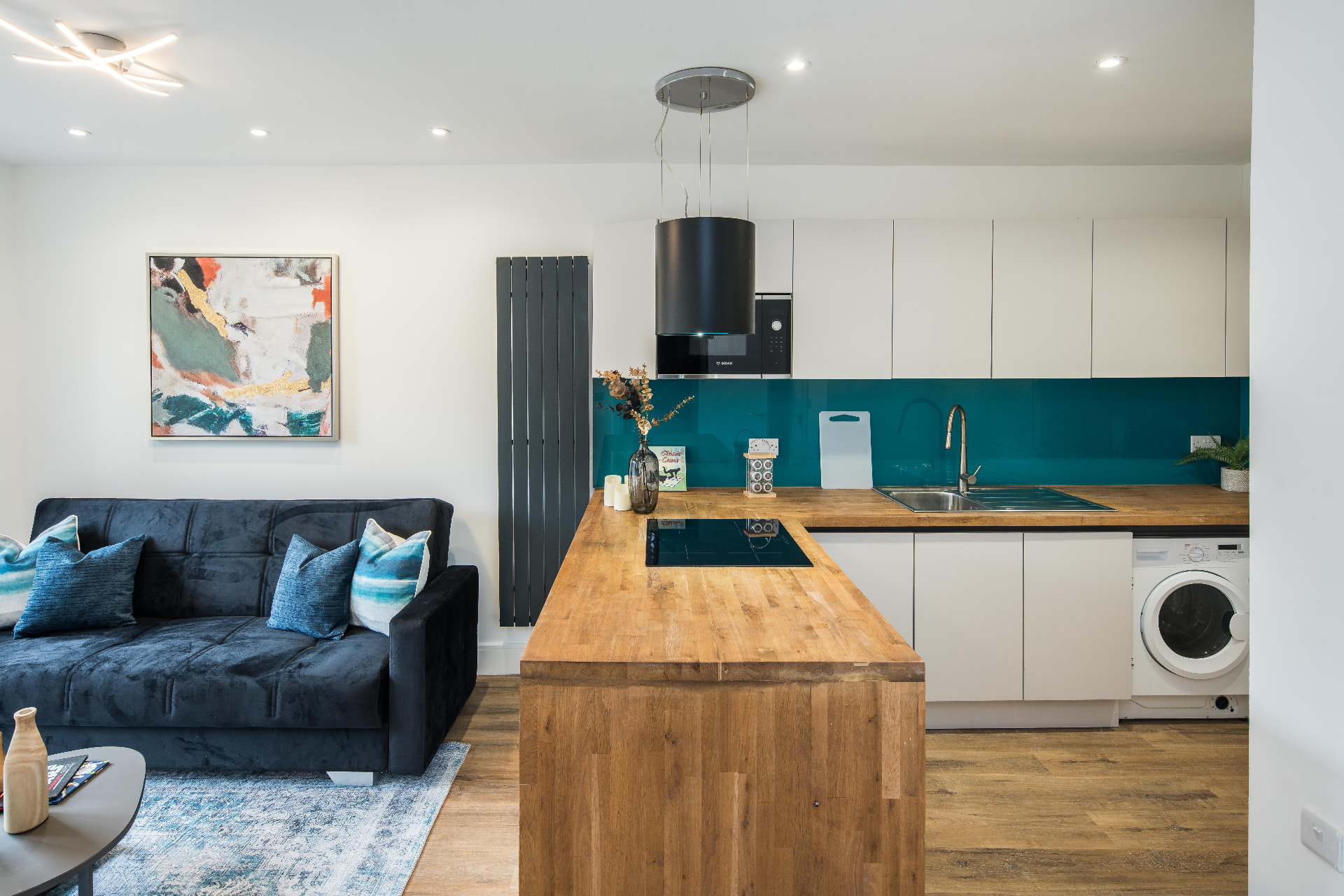 Kitchen island seating area beside a glazed splashback.